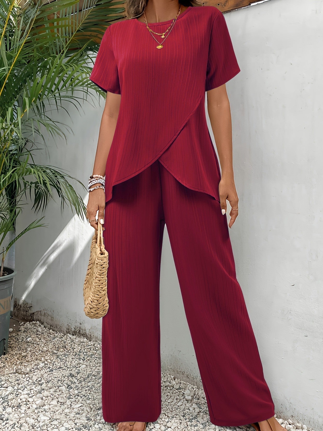 Conjunto de dos piezas con blusa cruzada y pantalón palazzo plisado.